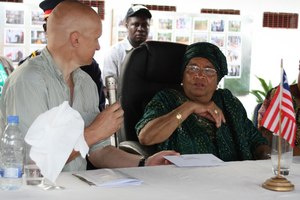 En avril 2011, les médias libériens ont rapporté que le PDG d’EPO, Peter Bayliss, avait fait passer une enveloppe contenant un chèque 25  000  dollars à la Présidente Sirleaf, lors d’une visite à la concession. (Photo  :  Frontpage Africa Online)