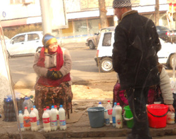 Ms. Zulaikho sells milk from her own cows to a customer in 
Tashkent, Uzbekistan, 8 January 2011. Sales of people's milk in 
Uzbekistan have recently risen. People appreciate its quality and 
freshness, and it sells for half the price of store-bought milk. The 
government and industry have responded by calling the milk unhygienic, 
and recently a campaign was launched in Tashkent to educate school 
children on the importance of drinking processed and packaged milk 
instead of people's milk. "Today’s young people will be future 
parents with a new outlook and with modern demands for quality 
products”, says the campaign's marketing agent, Saida Ziyamova. “So it 
is important to convey to them the importance of healthy, safe milk.” 
When asked why many people in Uzbekistan believe people's milk to be 
superior in quality, Nestlé Uzbekistan’s plant manager, Muzaffar Akilov,
 explained: “People get mixed up out of ignorance."