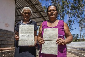 Two women from the village of Santa Fé in the municipality of Santa Filomena display their land certificates, September 2017. The people of Santa Fé have lived in this part of the Brazilian state of Piauí for over 200 years but are now affected by a recent wave of land grabbing in the area, led by Brazilian businessmen and financed by foreign companies, such as Harvard’s endowment fund and the US-based pension fund manager TIAA. (Foto: Rosilene Miliotti / FASE)