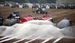 Dairy farmers in Belgium in 2009 spraying milk in fields to demand better prices. That year, prices paid to farmers for milk plunged to €0.20–0.24 a litre, half the cost of production (Photo: ANP).