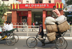 When fast-food chains like McDonald's move into new markets in the South, so do their global suppliers. McDonald's main global suppliers of dairy products, Schreiber Foods and Eerie Foods, entered India in the late 1990s to develop a regional supply base for the restaurant. At the behest of McDonald's, the companies partnered with the wealthy Goenka family to establish a large dairy-processing company in Maharashtra, now called Schreiber-Dynamix. The company began by setting up contract farming and collection centres to collect milk from local farmers, but then began building its own large-scale farm to supply its needs. In November 2010, the company inaugurated a "future ready" 6,000-cow dairy farm on 300 acres in Pune District, with backing from the State Bank of India. Dynamix also supplies Danone, Nestlé, Yum! and KFC (Photo: USC).